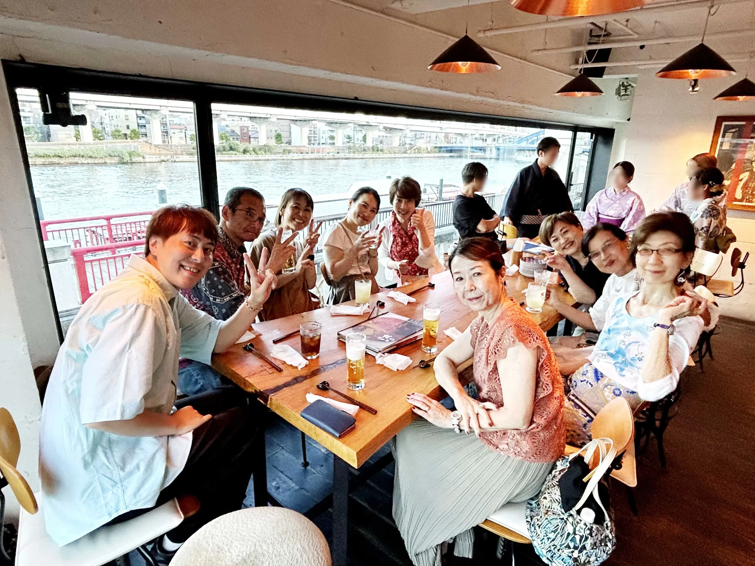 テーブルを囲み、色とりどりのドリンクを持って笑顔で乾杯する男女グループ。楽しげな交流会のひととき。